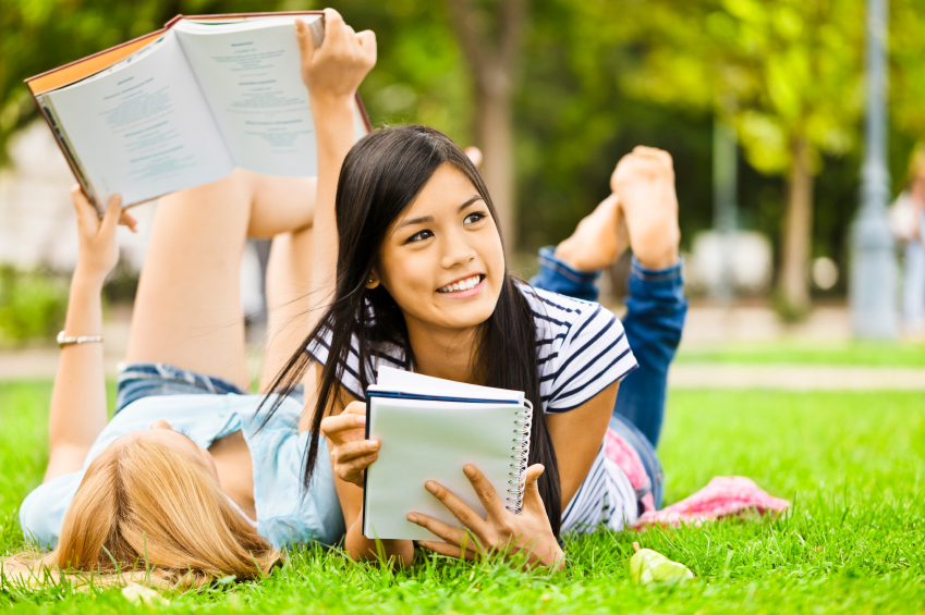 Teenage Girls Reading Books on Lawn